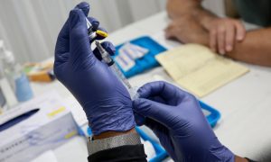 2022 年 7 月 12 日，美国佛罗里达州，一名医护人员准备给一个人注射预防猴痘的疫苗。