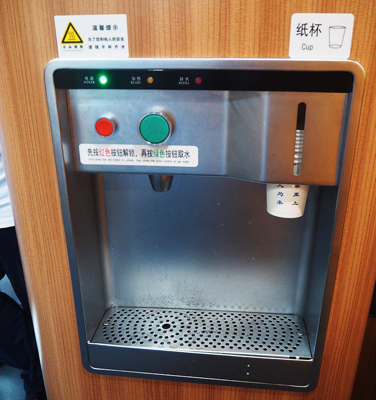 中国火车上的饮水器，红色按钮是安全锁，绿色按钮用于放热水
