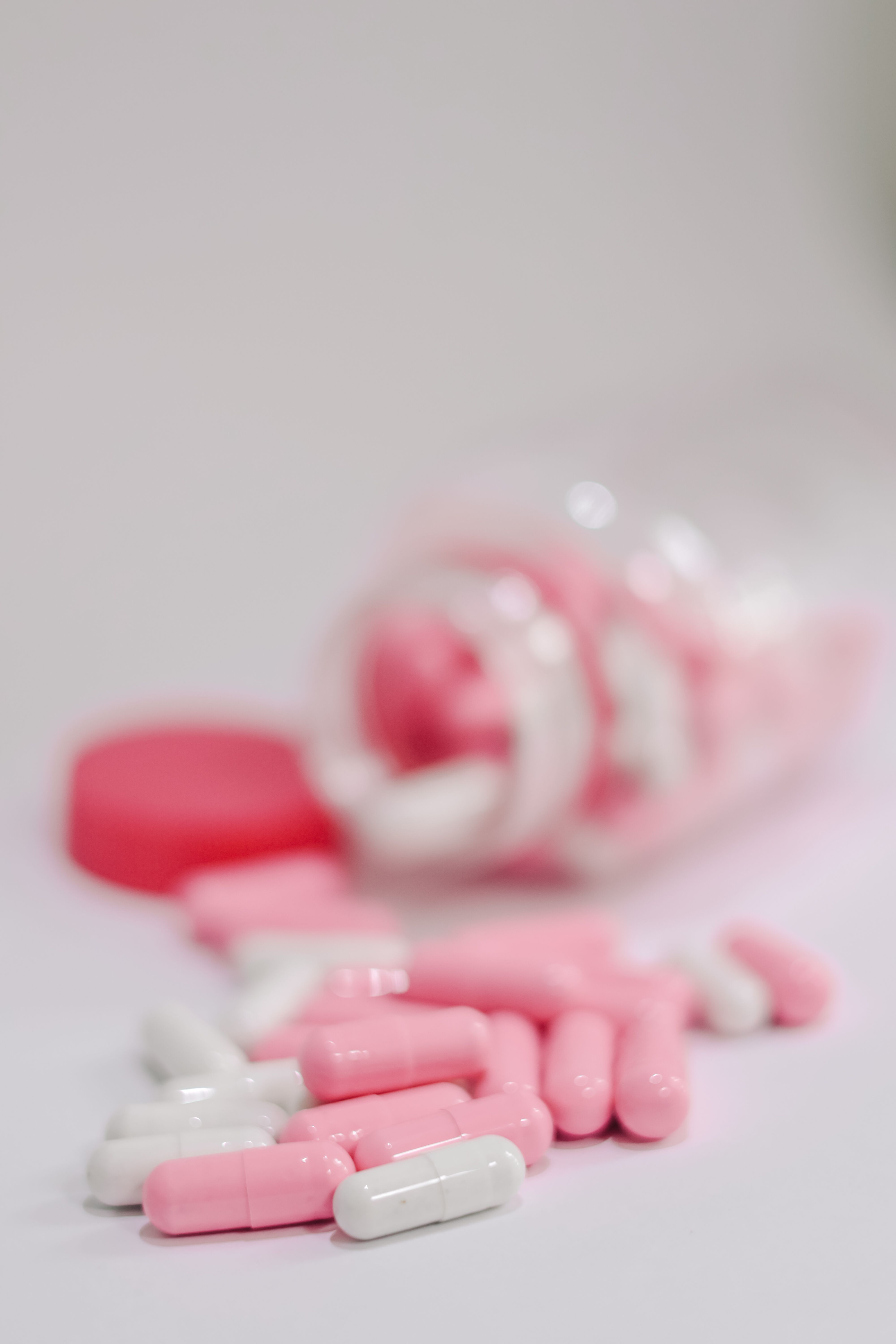 Medicine bottle with pink and white capsules