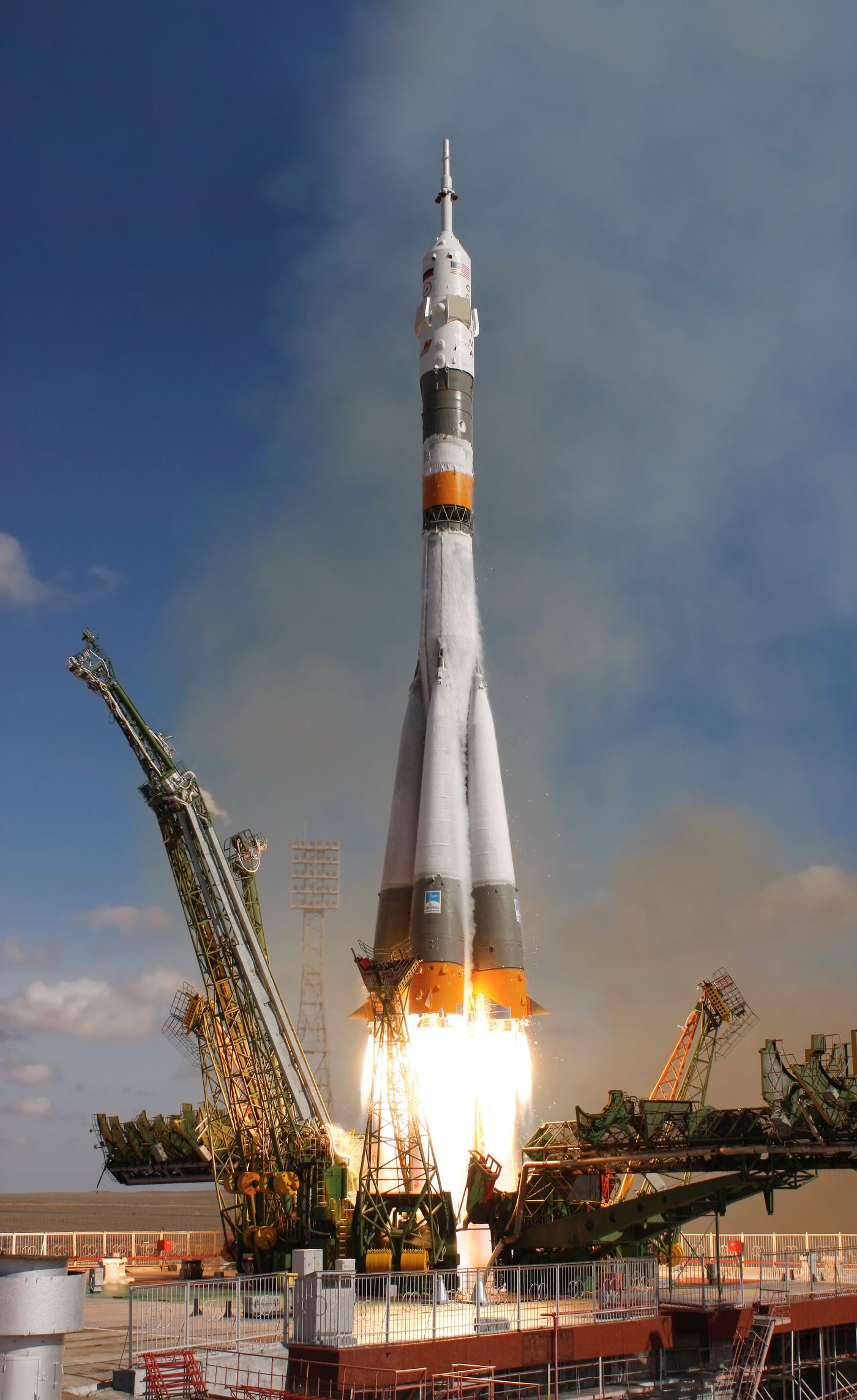 Rocket launching into blue sky with exhaust flame