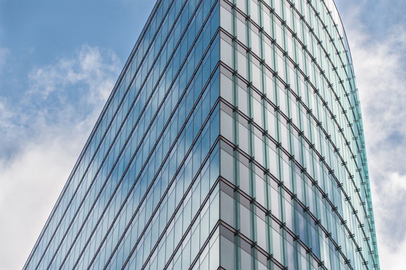 Modern glass skyscraper against blue sky